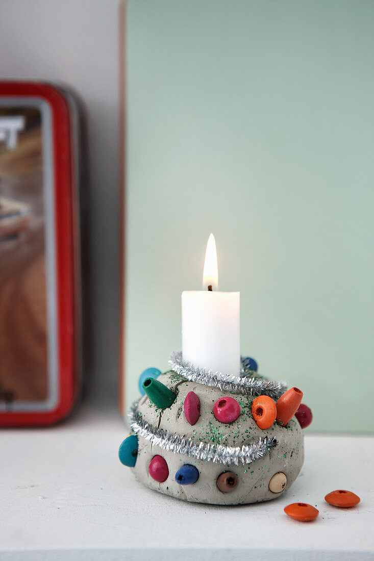 Selbstgemachter Kerzenständer aus Ton mit bunten Holzperlen