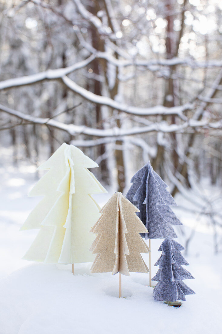 Handmade felt Christmas trees in snowy garden