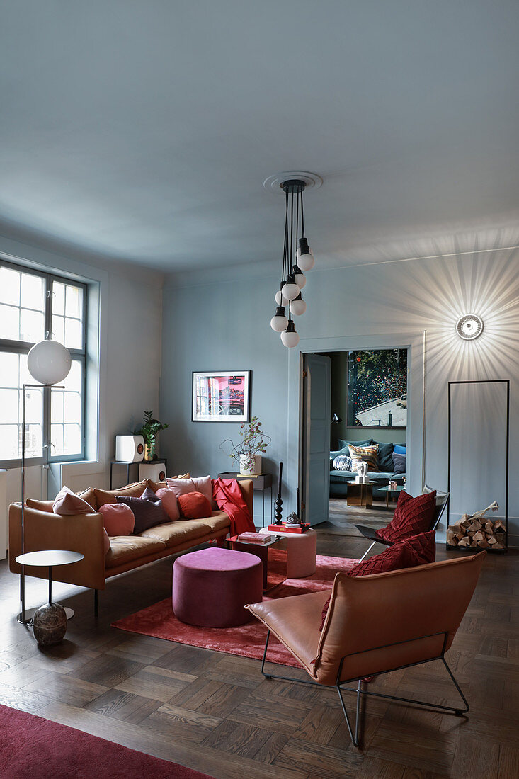 Leather sofa and easy chairs in living room in muted shades
