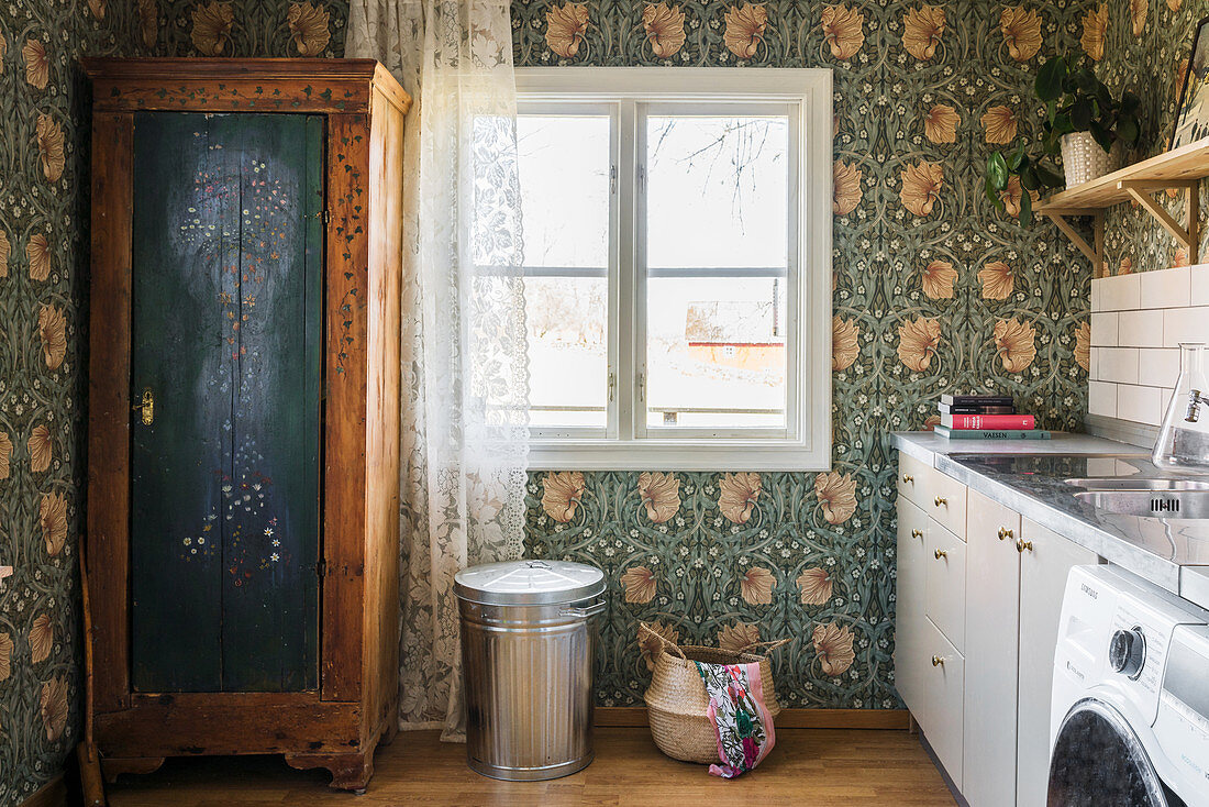 Old wardrobe in laundry room with vintage-style floral wallpaper