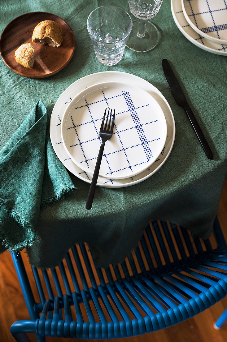 Teller mit blauem Karomuster auf dem Tisch mit grüner Tischdecke