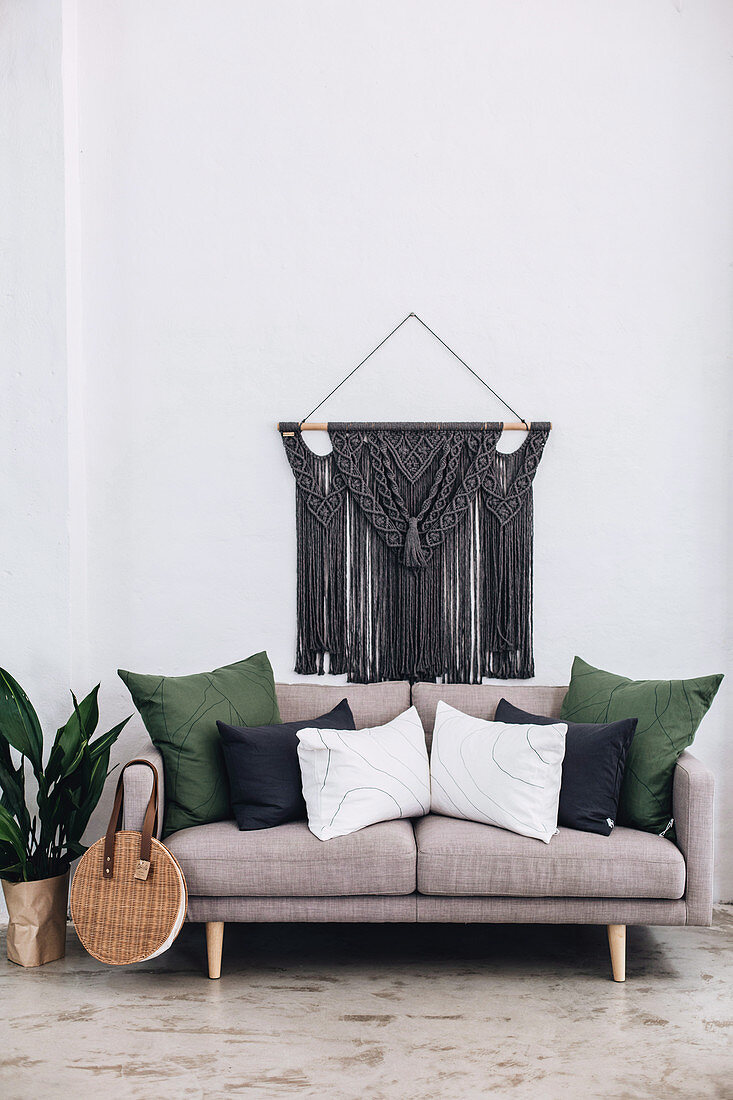 Knotted wall hanging with macramé over sofa