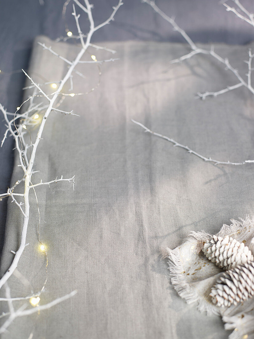 Festive table decoration with fairy lights and pine cones