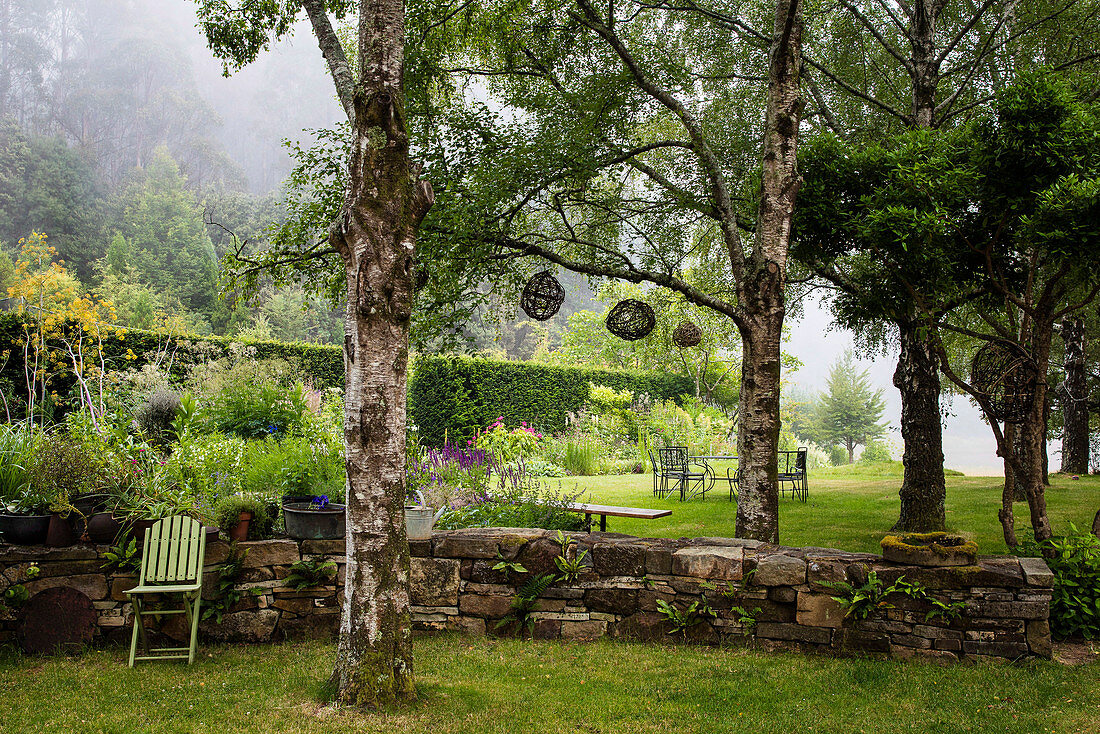 Natursteinmauer im sommerlichen Garten am Waldrand