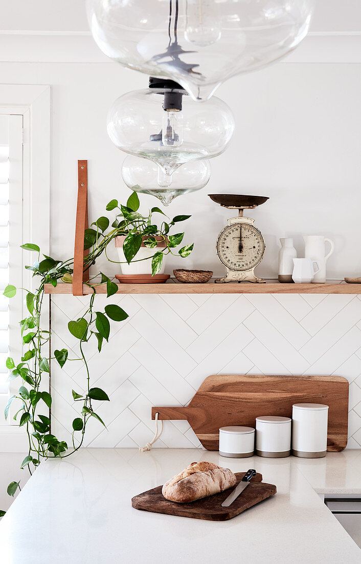 Küchenarbeitsplatte über Eck, darüber Regal mit Zimmerpflanze und Vintage Waage