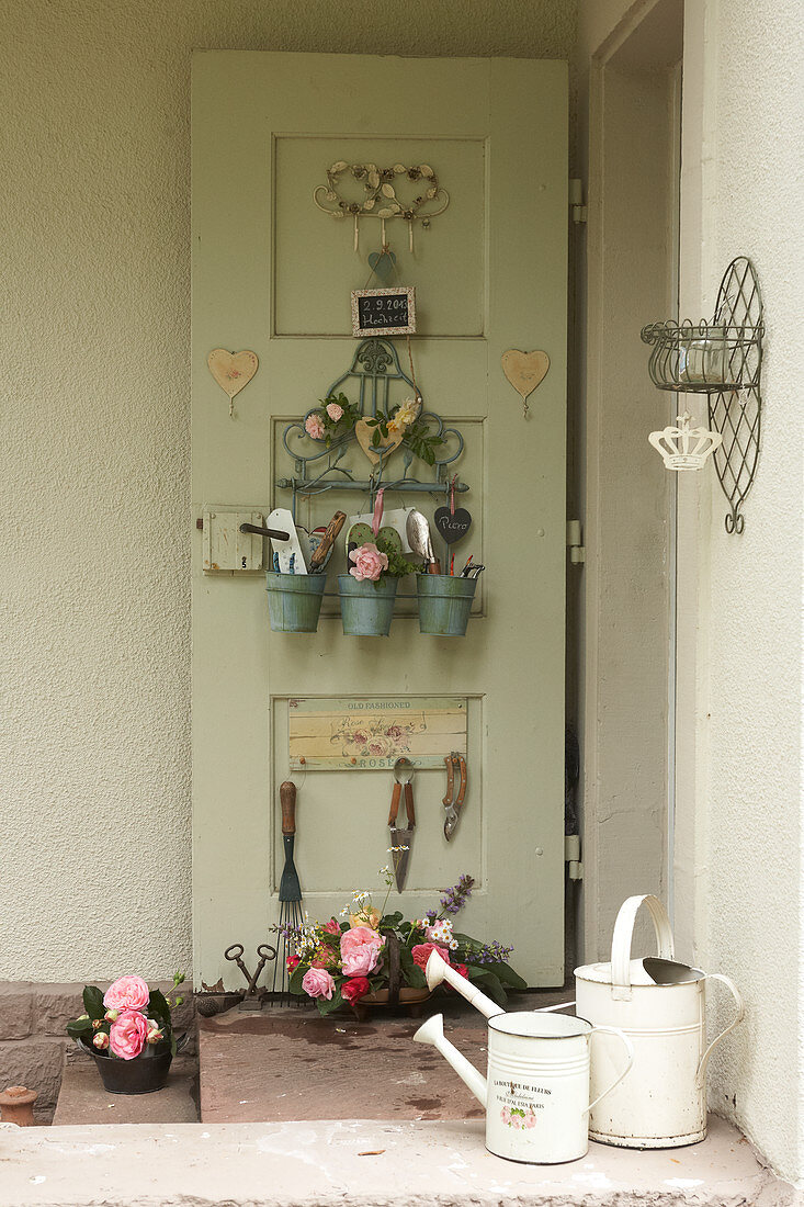 Organiser and utensils hung on inside of back door and basket of flowers on floor