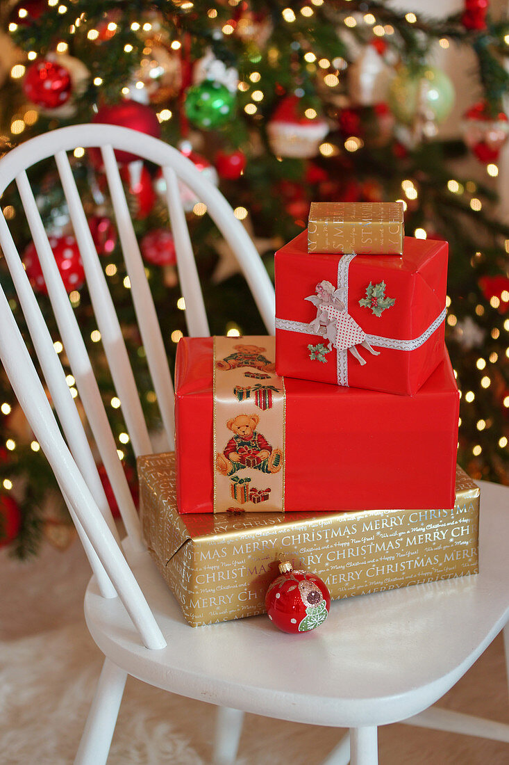 Festively wrapped Christmas presents on white chair
