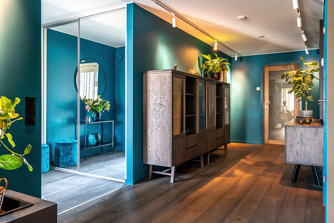 Hallway with dark wooden floor and turquoise walls