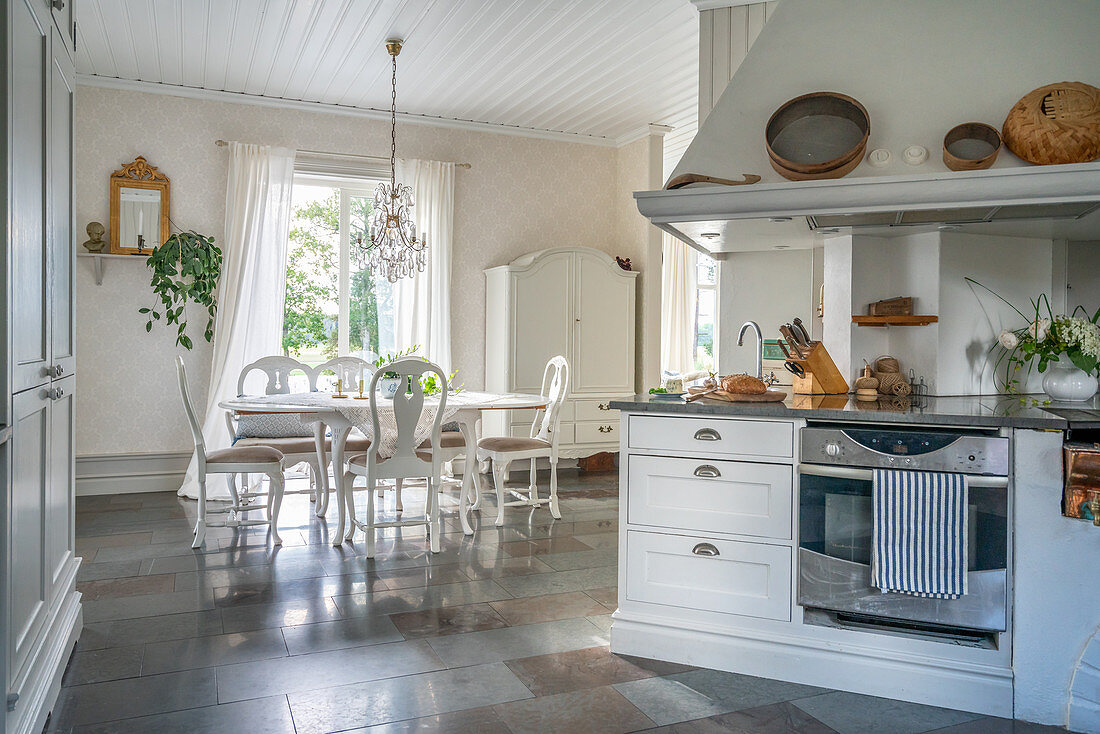 Offene Küche im Landhausstil und Esszimmer mit Steinboden
