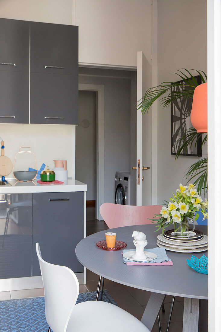 Runder Esstisch in kleiner Wohnküche mit grauen Fronten