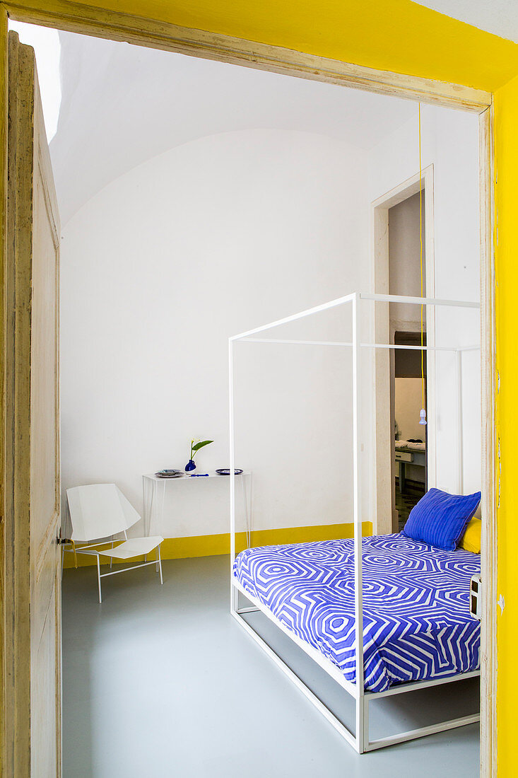 Blick ins Schlafzimmer mit gelben und blauen Farbakzenten
