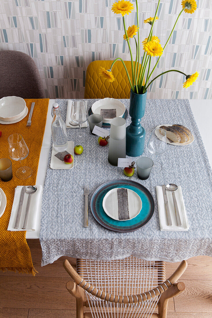 Table set with tablecloth and vase of flowers