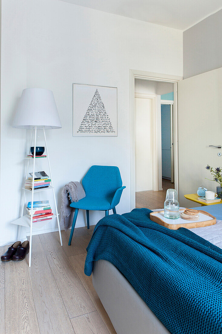 Blue armchair in small reading area in bedroom