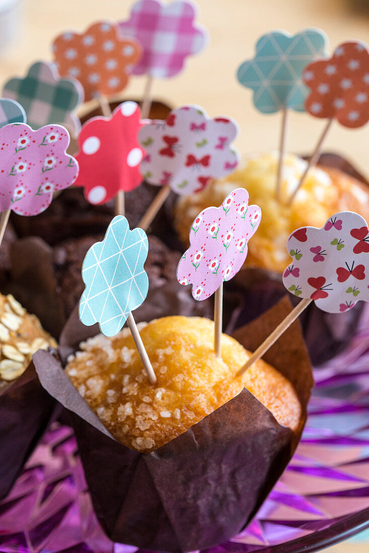 Muffins decorated with handmade paper flowers on toothpicks
