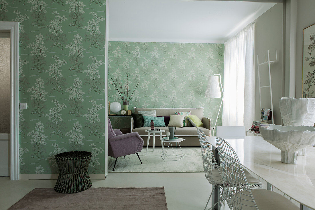 View from dining area into lounge with green wallpaper and pastel furniture