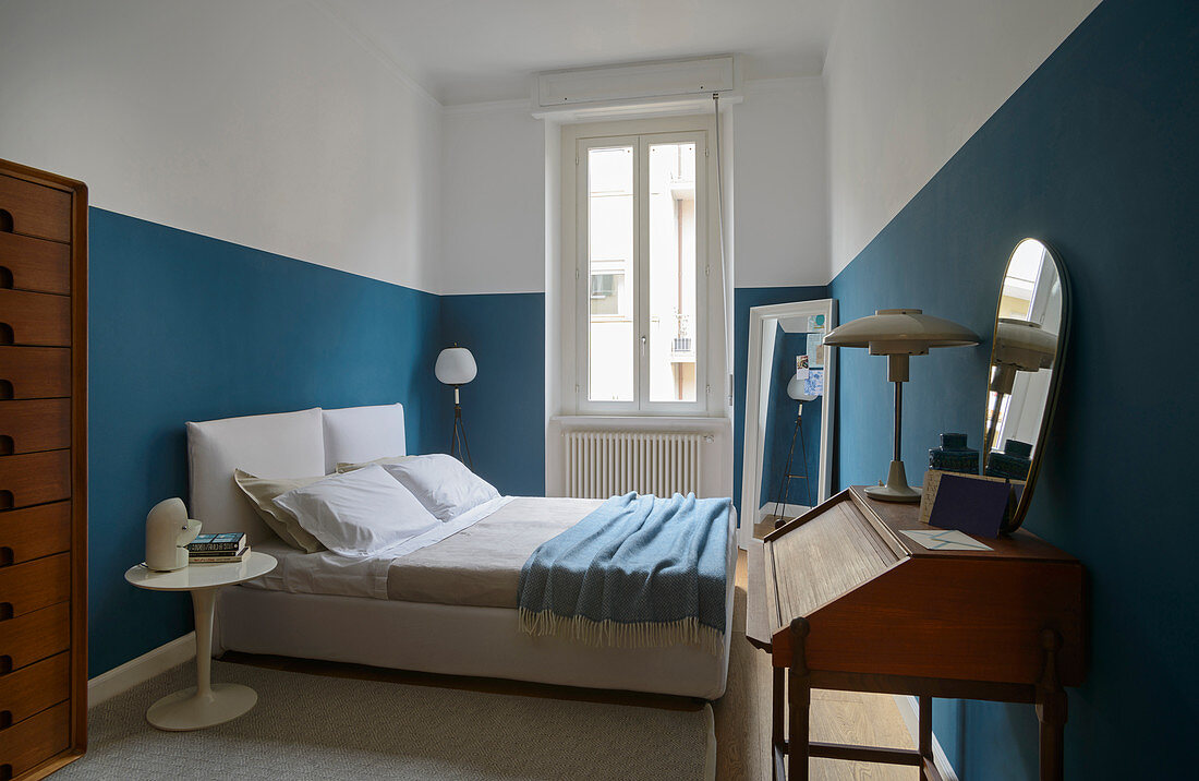 Schlafzimmer im Retrostil mit halbhoch blau gestrichenen Wänden