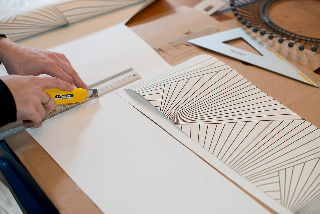 Cutting pieces of graphic wallpaper with a utility knife