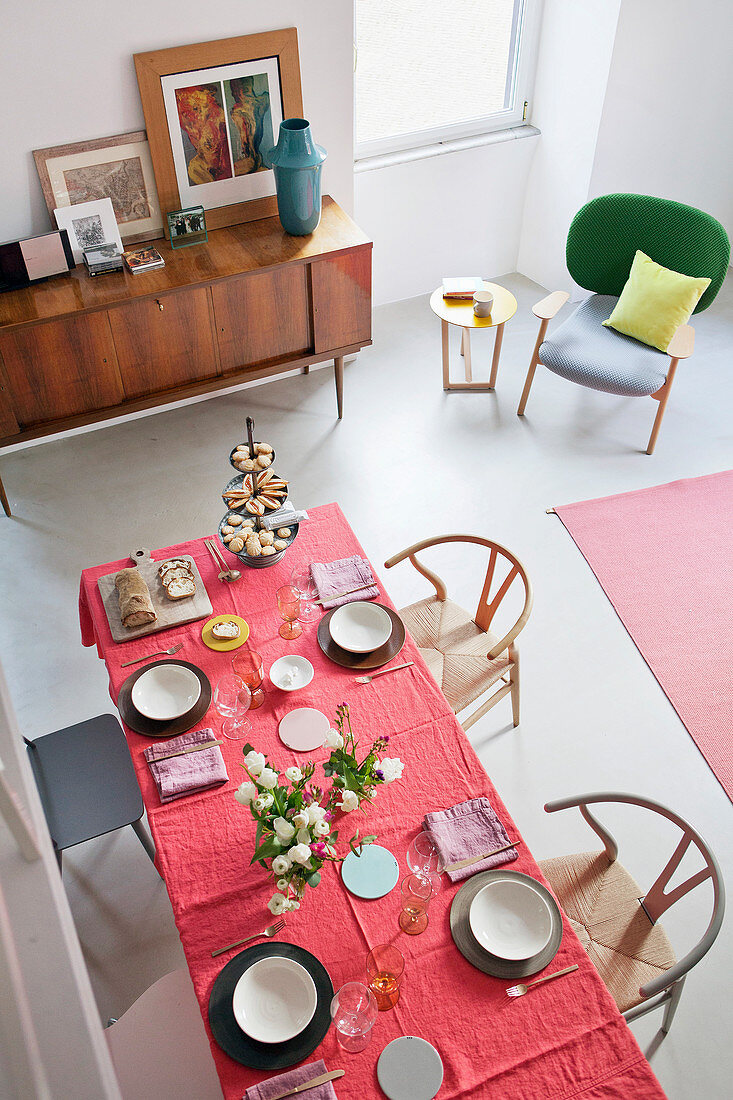 Blick von Mezzanin auf gedeckten Esstisch in kleinem Apartment