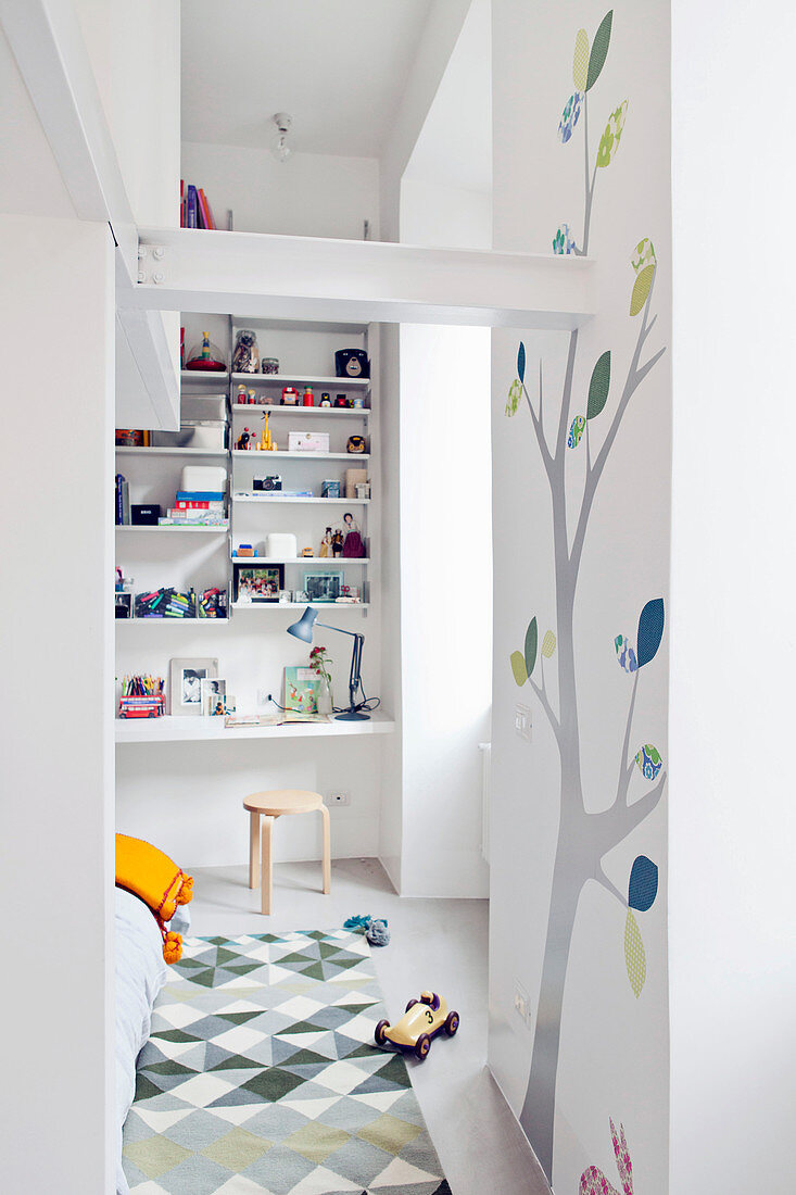 Doorway leading into children's sleeping area with desk and tall shelving