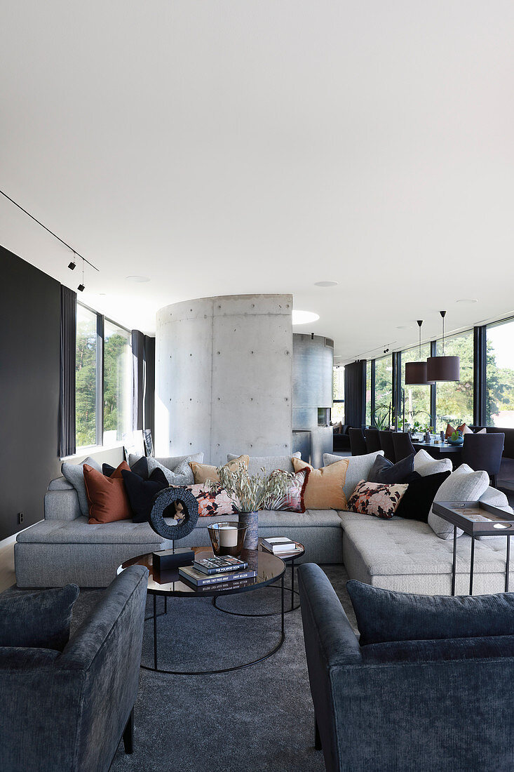 Sofa und Sessel im luxuriösen offenen Wohnraum in Grautönen