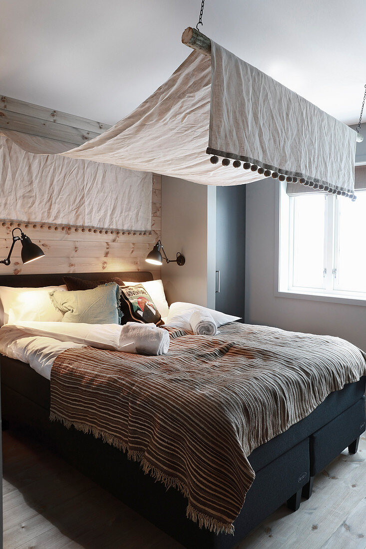 Schlafzimmer in Naturtönen mit Baldachin und Holzverkleidung