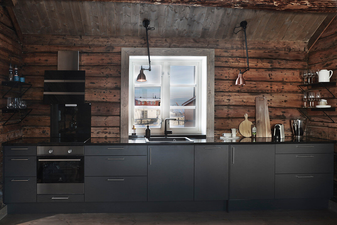 Moderne Einbauküche mit grauen Fronten in rustikaler Holzhütte