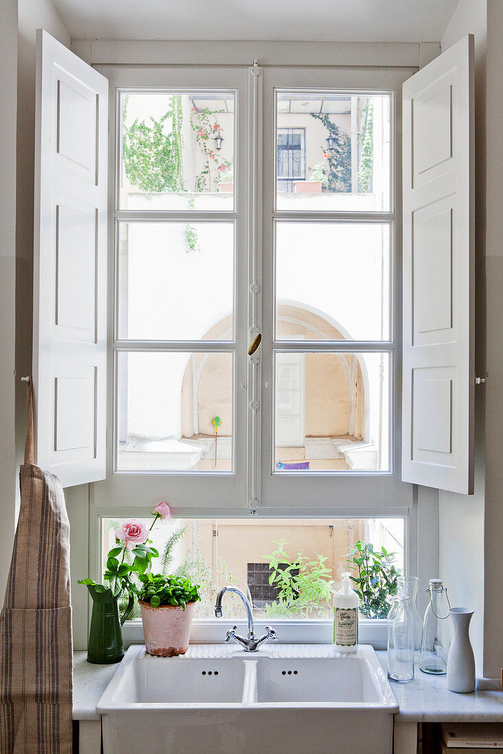 Sink below lattice window with white interior shutters