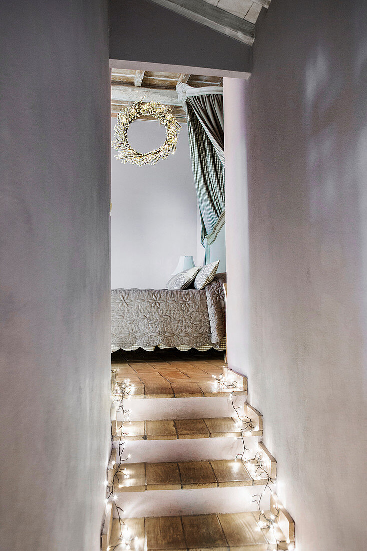 Steps decorated with fairy lights leading to bedroom