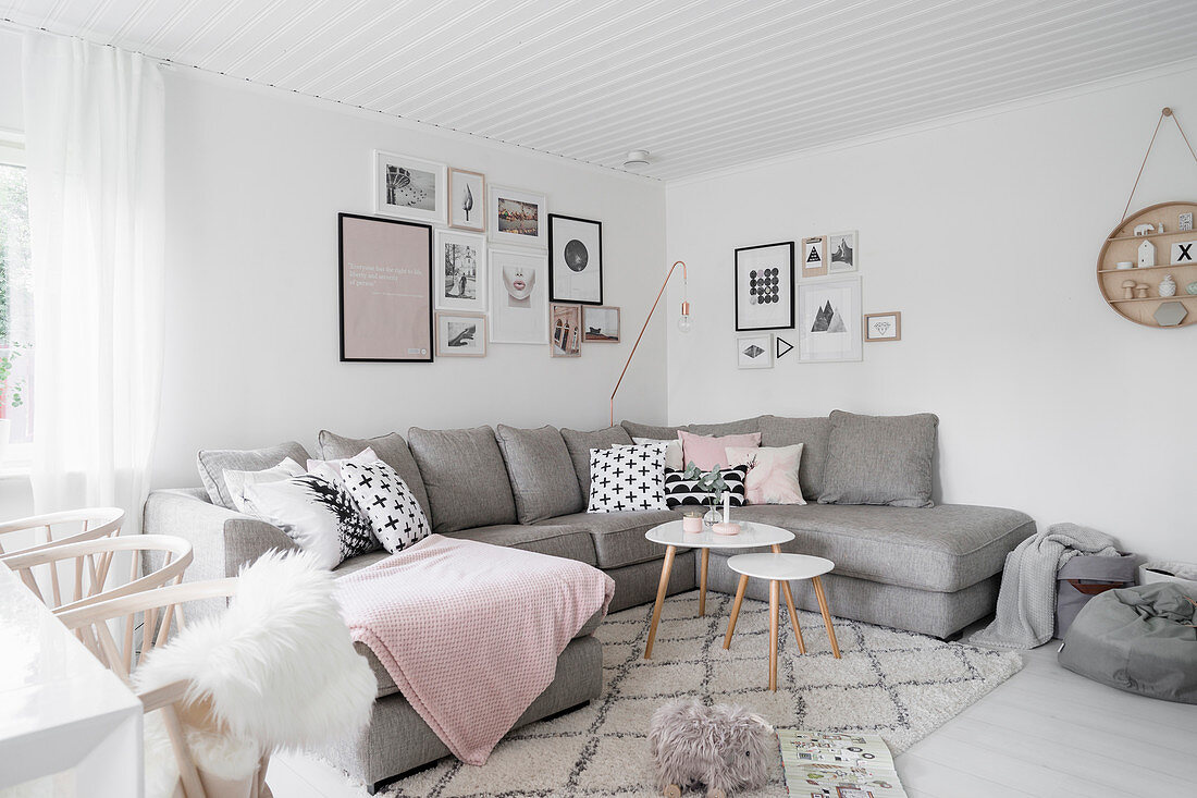 Scatter cushions with graphic patterns on grey sofa below gallery of pictures