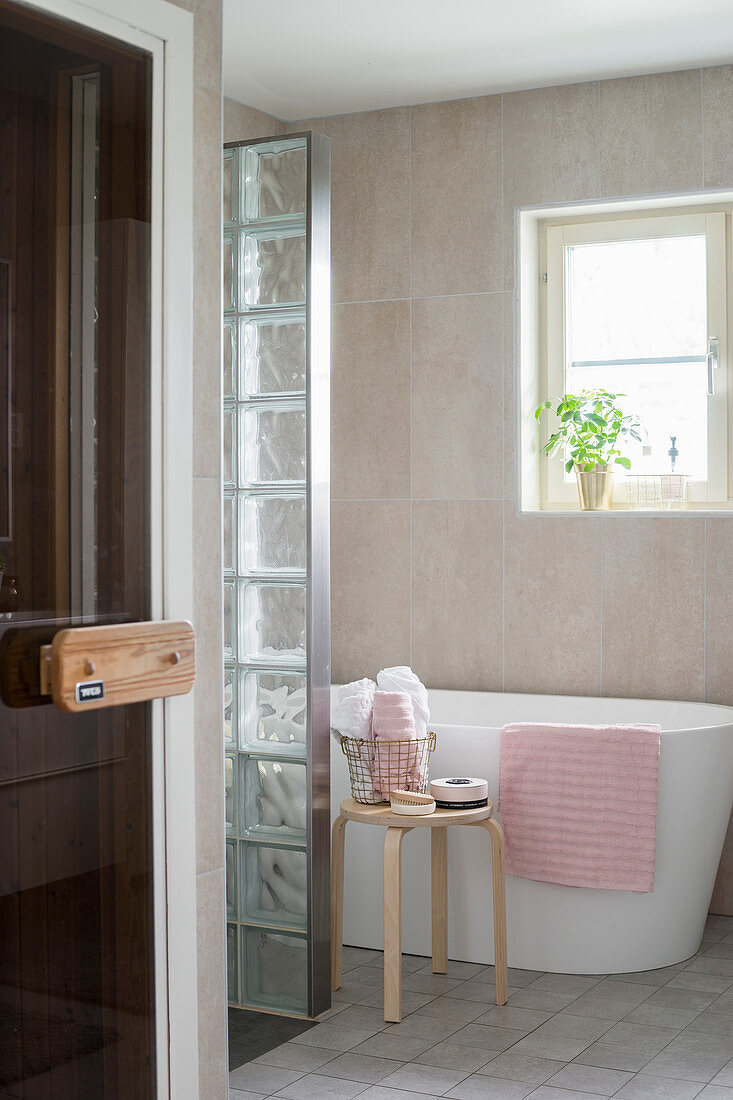 Moderne freistehende Badewanne mit Trennwand aus Glasbausteinen