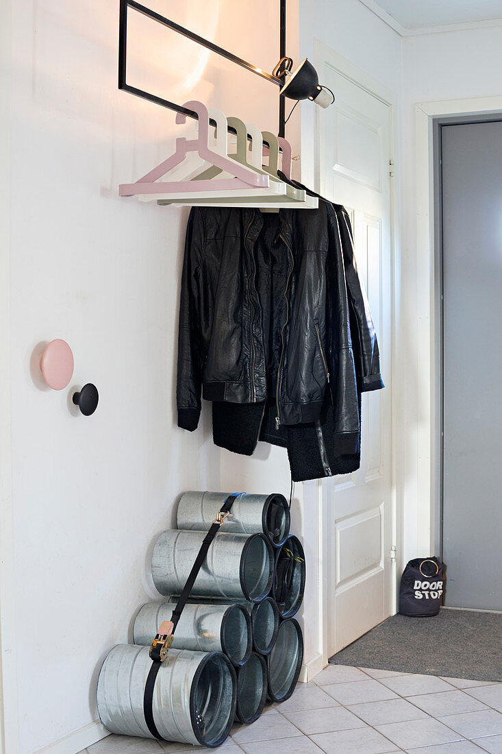 Shoe rack made from pipes bound with lashing strap below coat rack