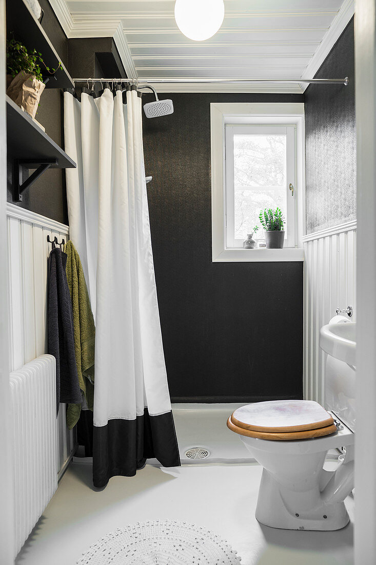 Kleines Duschbad mit schwarzen Wänden und weißem Boden