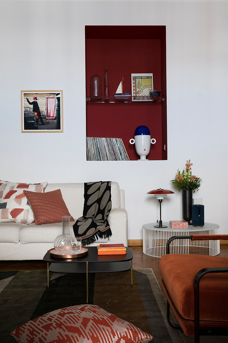 Sofa unter einer roten Wandnische im Wohnzimmer im Desingerstil
