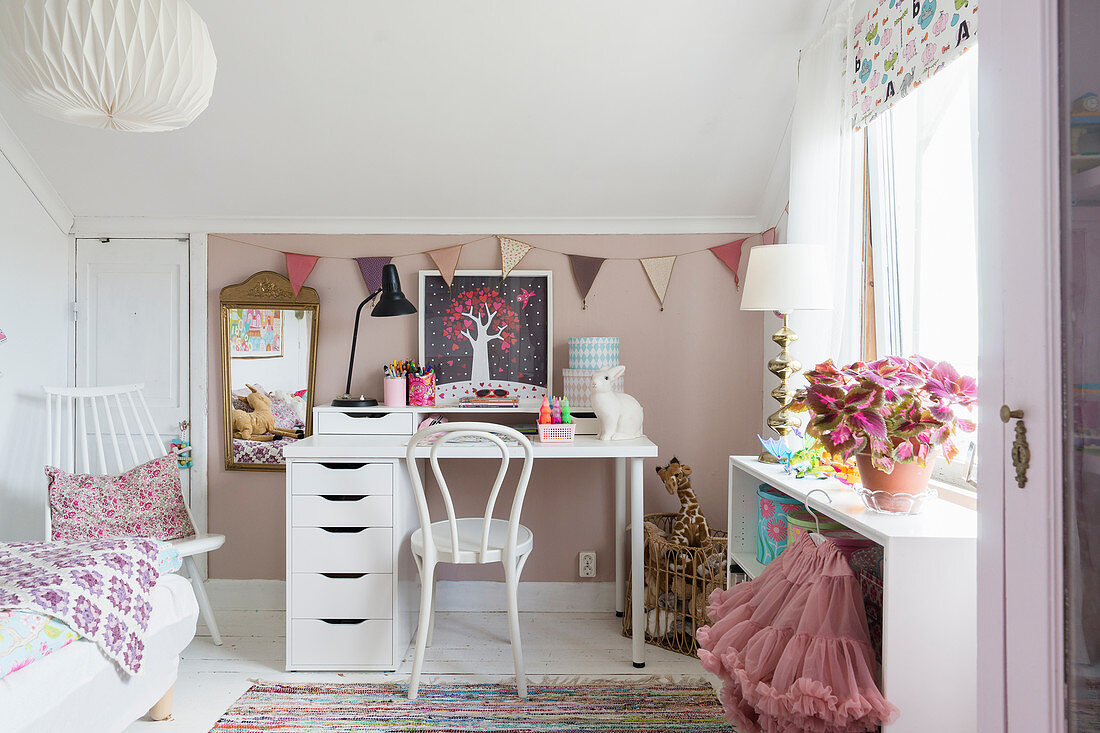 Bistrostuhl am Schreibtisch vor rosafarbener Wand im Kinderzimmer