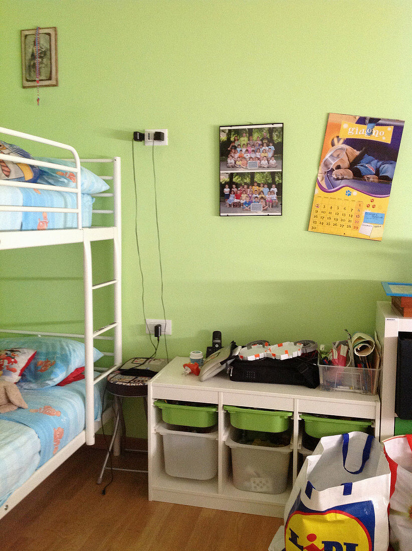 Etagenbett und Aufbewahrungsmöbel mit herausziehbaren Boxen in grünem Kinderzimmer