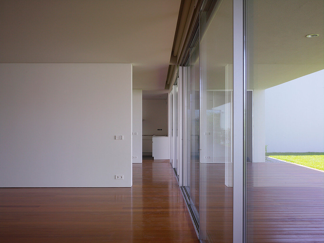 Consecutive doorways between partition walls and glass walls in minimalist house