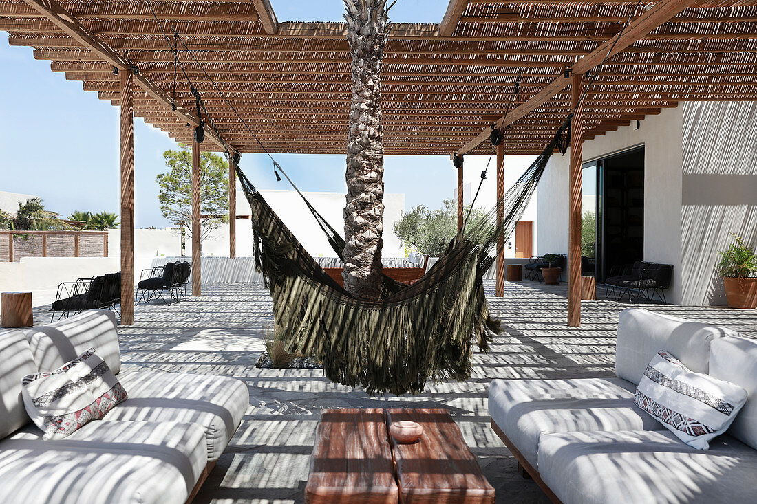 Hängematten und Loungebereich auf strohgedeckter Sonnenterrasse