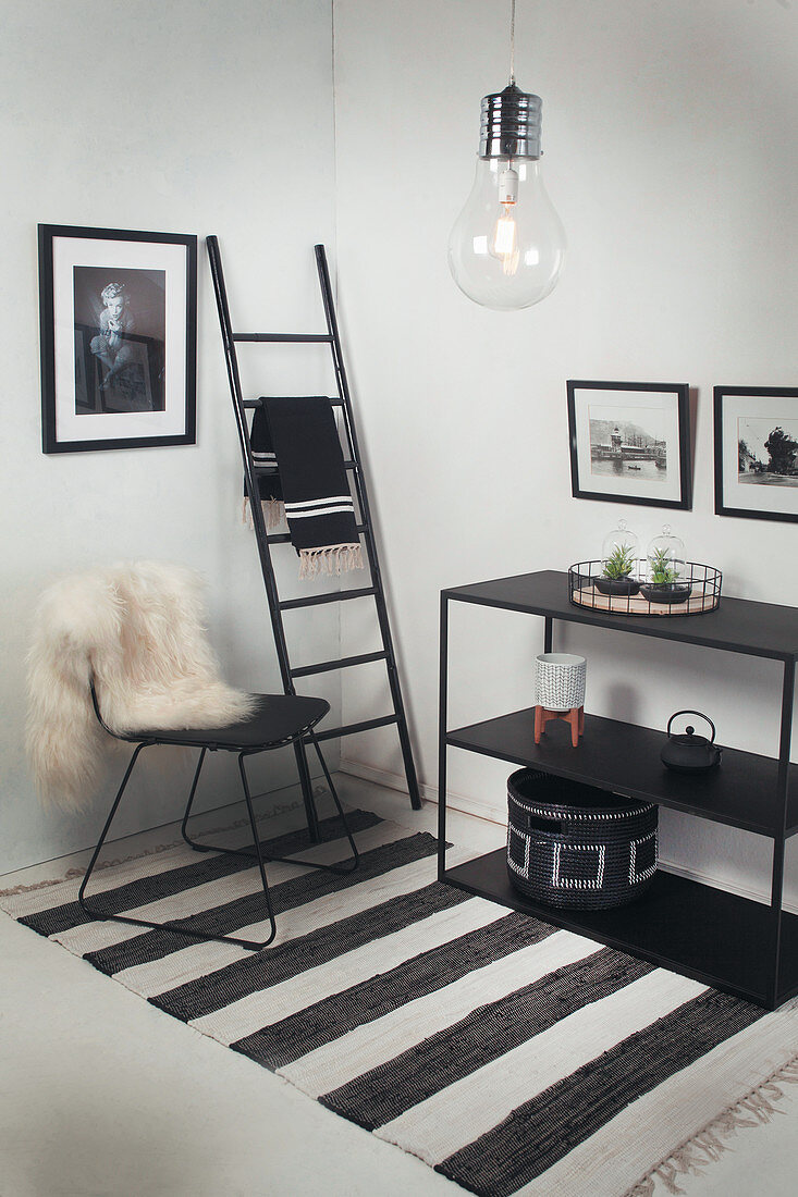 Wohnraumecke in Schwarz-Weiß gestaltet mit Stuhl und Regal