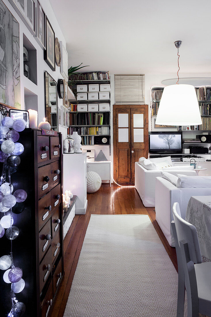 Wohnzimmer in Weiß mit Kommode, Dielenboden und Holztüren als braune Akzente
