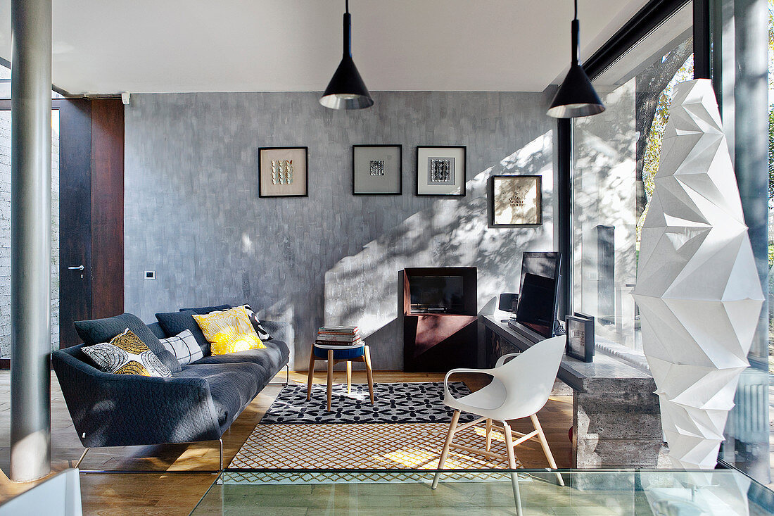Gemütlicher Sitzbereich in modernem Architektenhaus mit gemusterten Teppichen und Designer-Stehleuchte