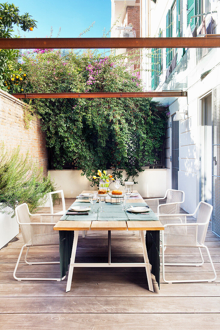 Set dining table in summery wooden terrace adjoining house