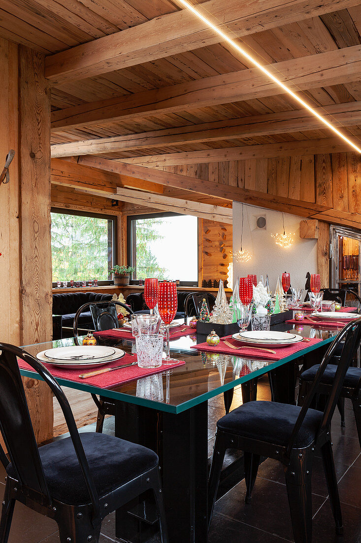Festively set table with black upholstered chairs in dining area of chalet