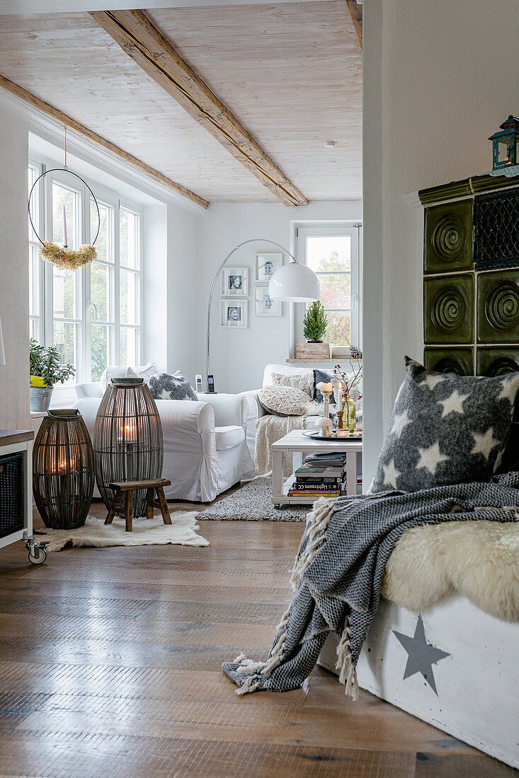 Blick ins Wohnzimmer mit Herbstdekoration in Shabby Style, im Vordergrund grüner Kachelofen