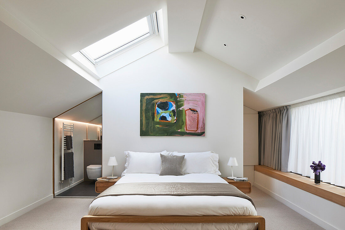 Doppelbett in hellem Schlafzimmer mit Dachfenster und Bad Ensuite