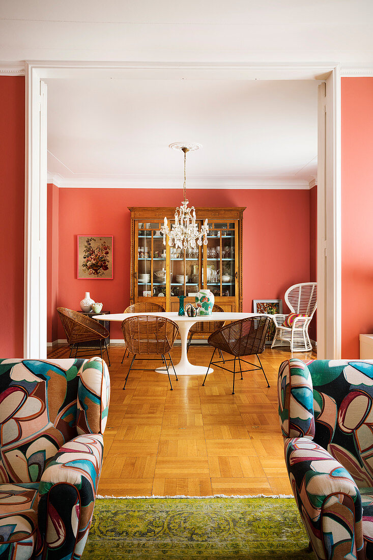 Eclectic furnishings in classic dining room with coral-red walls