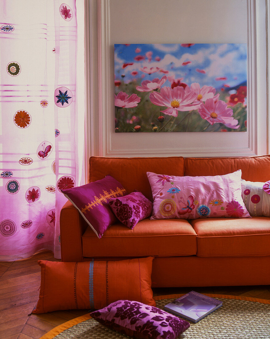 Orangefarbenes Sofa mit pinkfarbenen Dekokissen