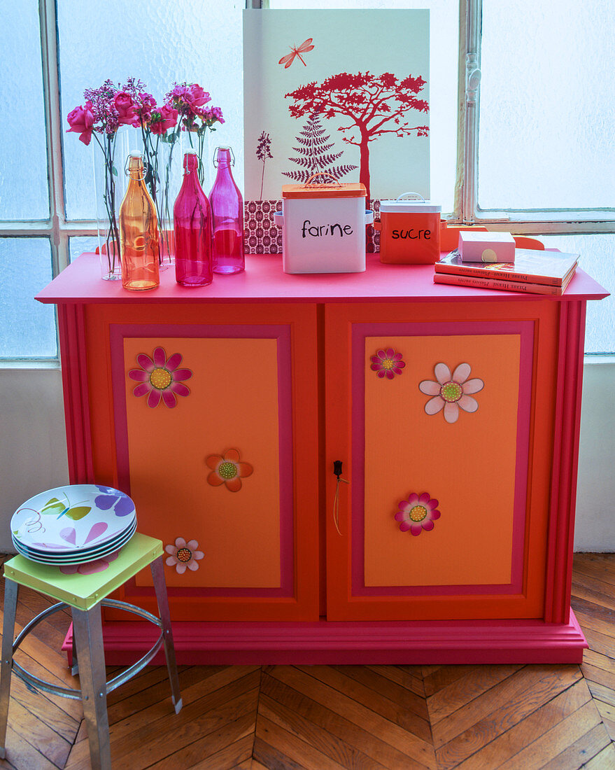 Cabinet decoratively painted in red, orange and hot pink