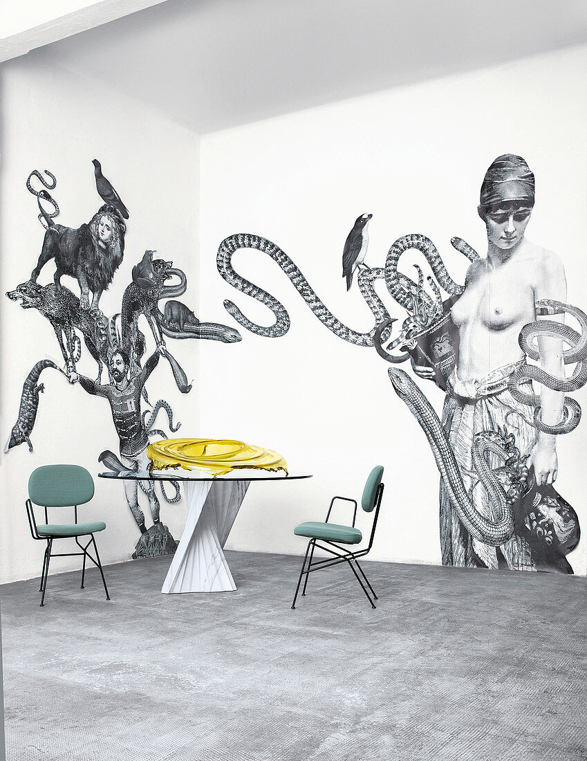 Schwarz-Weiß Collage an der Wand; Designertisch und Stühle