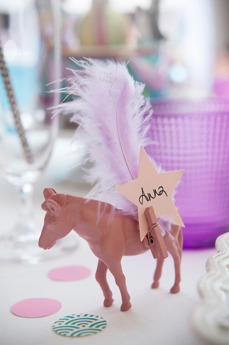 Name tag and feather on toy horse painted pink