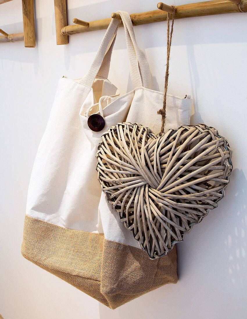 Cloth bag and love-heart decoration hanging from bamboo coat rack